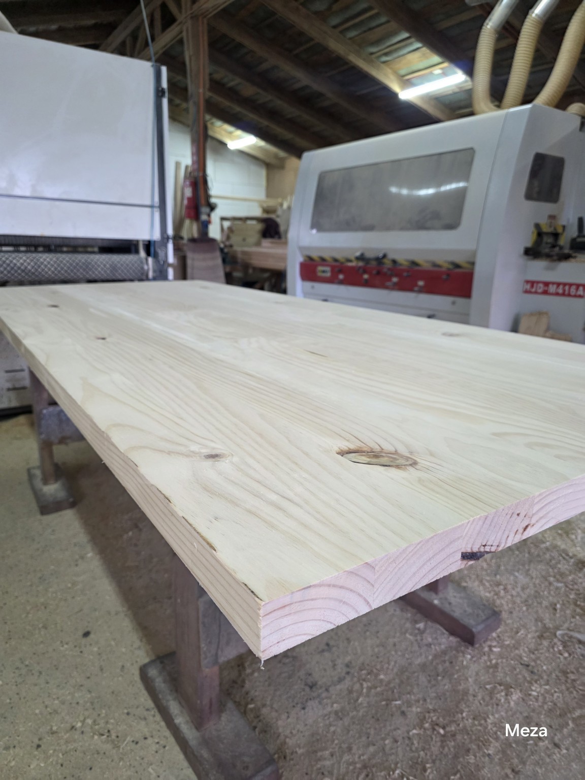 Tablero de madera en el taller, con vista de su superficie y espesor